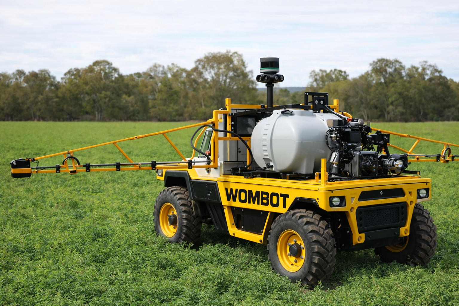 Wombot fitted with a spray rig in a field